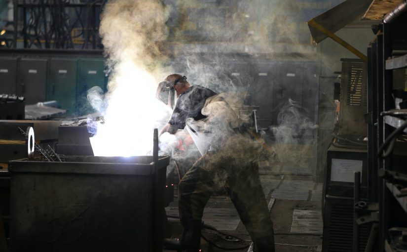 man wearing welding mask covered in welding smokes