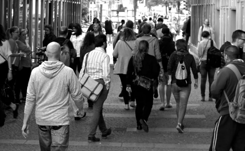 grayscale photography of people walking near buildings